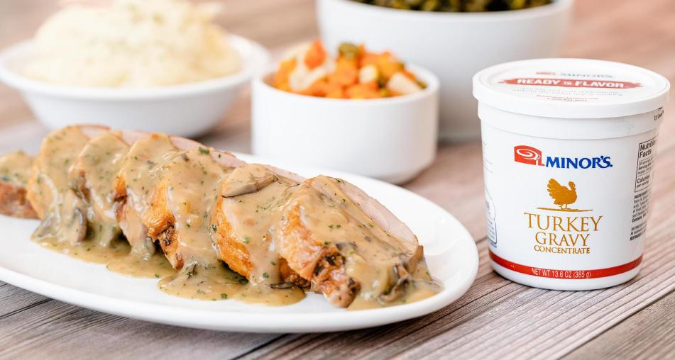 Sliced turkey and gravy next to a tub of Minors Turkey Gravy concentrate