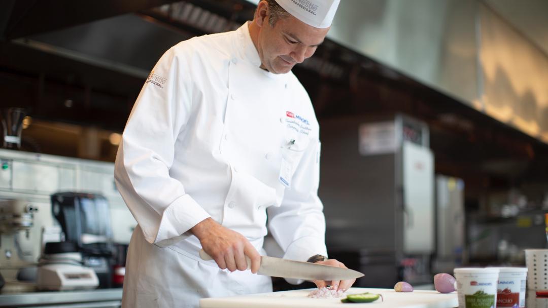 Chef Christopher Britton chopping onions in the kitchen