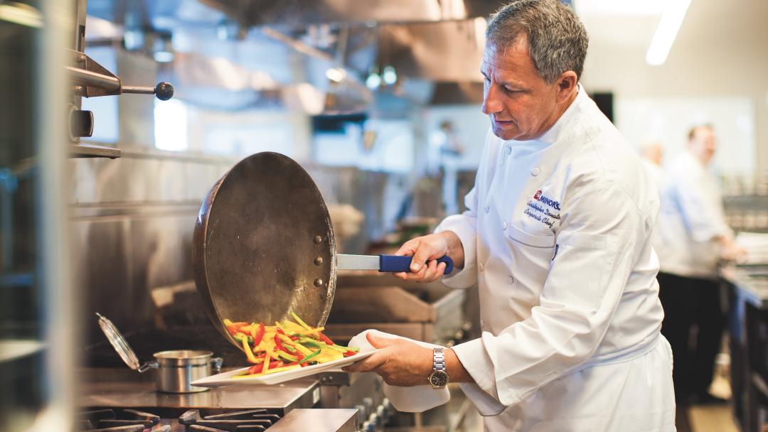 Chef Chris Donato plating vegetables in the kitchen