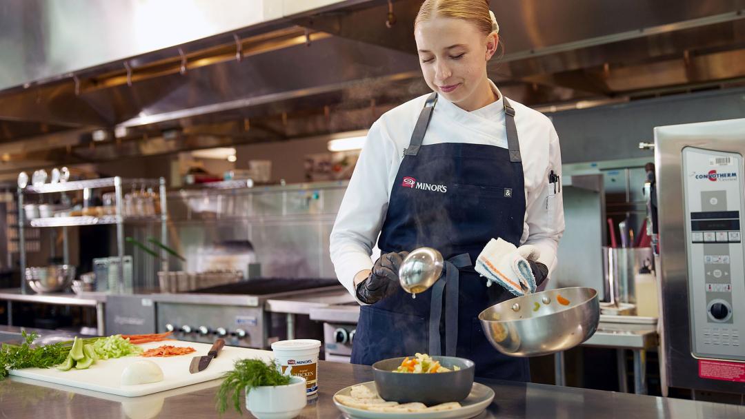 Chef SyEnna preparing soup in a kitchen