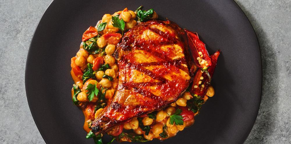 A porkchop with harissa sauce and vegetables