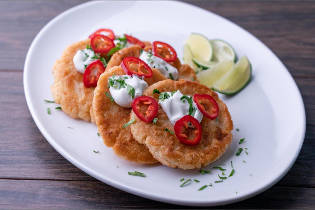 Four Ancho Chile & Cheese Pupusas on a plate with limes