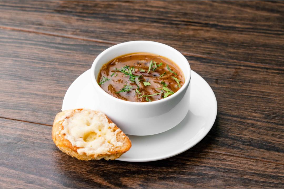 Five Onion Soup in a bowl with bread