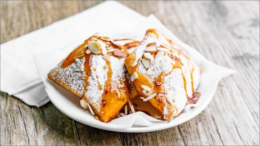 Two Ricotta and Goat Cheese Beignets on a plate with napkins