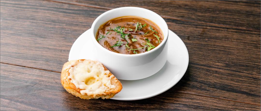 Five Onion Soup in a bowl with bread