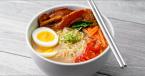 Spicy Pork Ramen Broth in a bowl with silver chopsticks resting on top